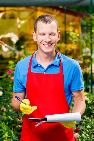 Happy successful businessman gardener in a greenhouse with a fol — Stock Photo, Image