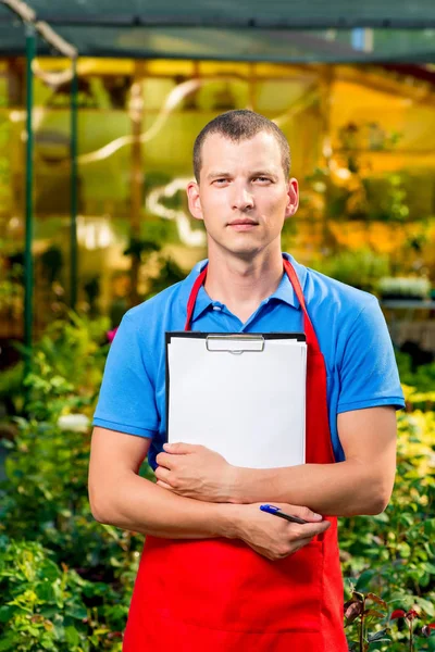 Verticale portret van een ondernemer in een kas met een blan — Stockfoto