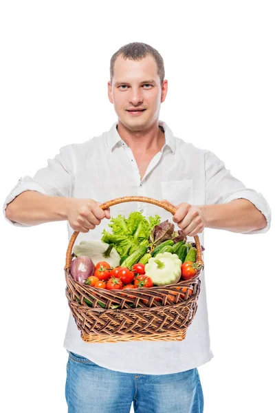 Lindo joven agricultor con una cosecha de verduras en un fondo blanco — Foto de Stock