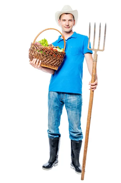 Farmář s vidlemi a košem zeleniny plnou délkou — Stock fotografie