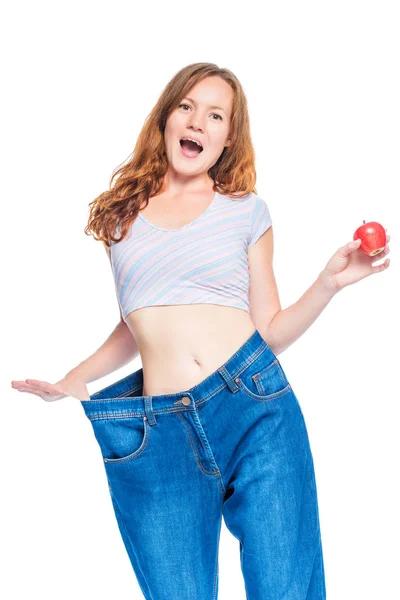 Happy slender girl shows the result of an apple diet on a white — Stock Photo, Image