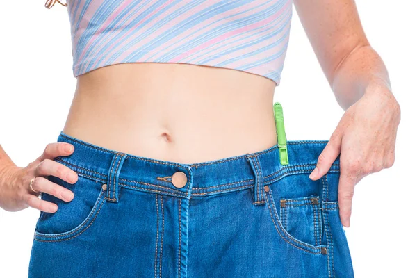 The result of an effective diet, a slim figure in large jeans cl — Stock Photo, Image