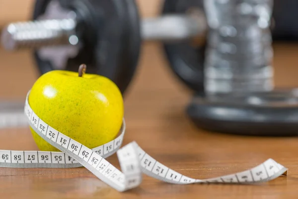 Fresh apple and centimeter close-up in the gym on the floor agai — Stock Photo, Image