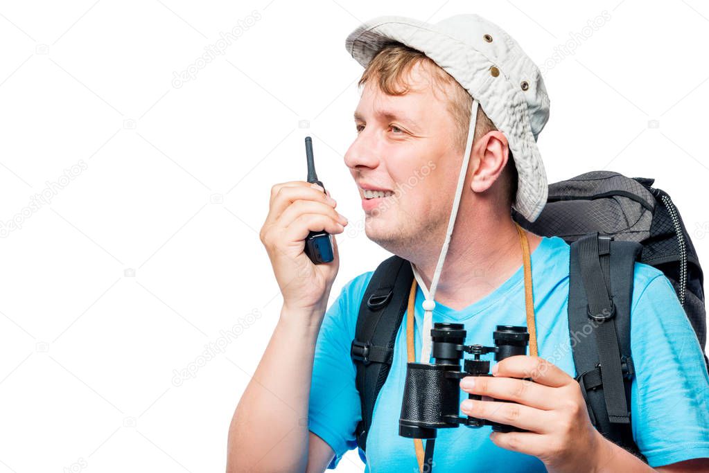 Happy traveler with walkie-talkie and binoculars on a white back