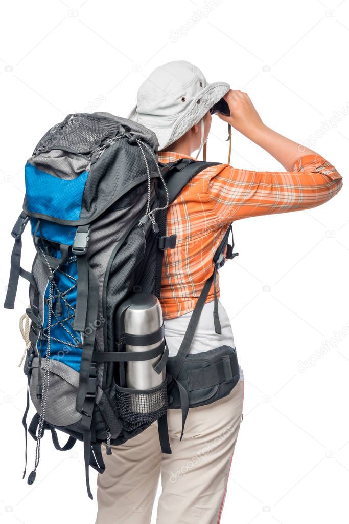 a woman with a large backpack is back and looking in binoculars