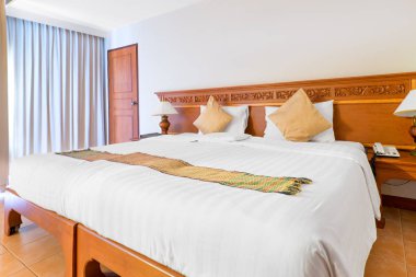 Yatak odasının içinde büyük bir çift kişilik yatak var.