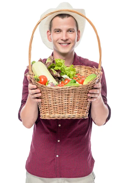 Smiling man shows a basket with grown vegetables in his garden i — Stock Photo, Image