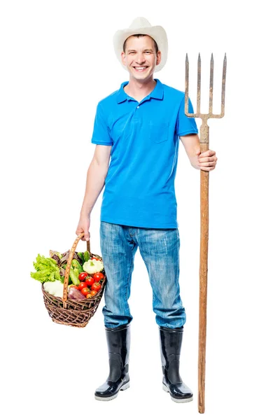 Happy farmář s vidličky a úrodu zeleniny na zádech, bílá — Stock fotografie
