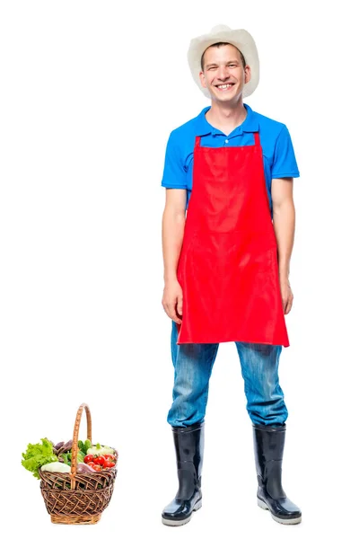 Homme en tablier agriculteur avec panier de légumes sur fond blanc — Photo