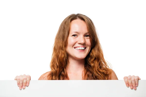 Chica sonriente con pecas sosteniendo un cartel sobre un fondo blanco — Foto de Stock