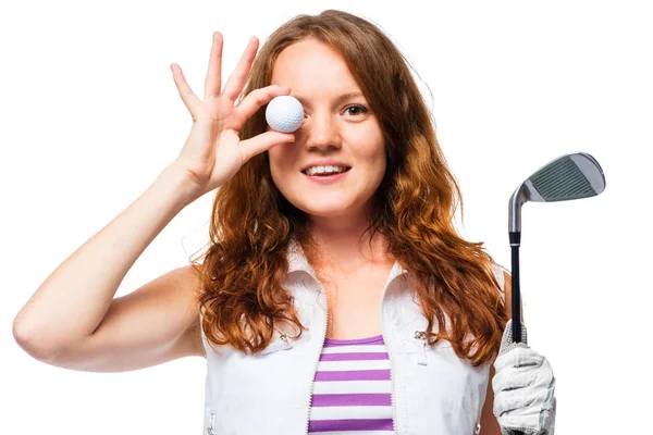 Hermosa chica con el pelo rojo y una pelota de golf en un fondo blanco —  Fotos de Stock