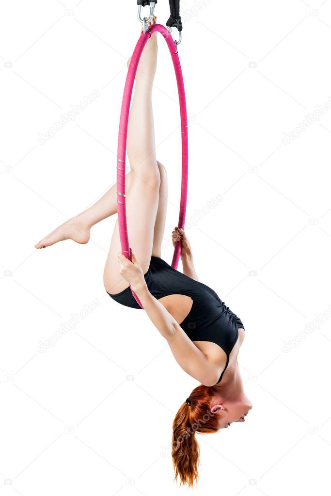 Red-haired athlete in the air ring trains isolated