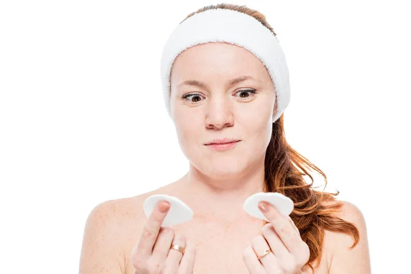 Surprised red-haired woman looking at cotton pads after cleansin — Stock Photo, Image