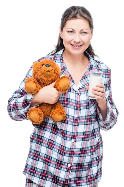 Krásná dívka v teplé pyžamo s milované medvěd a mléka na — Stock fotografie