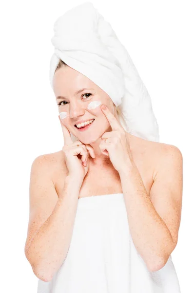 Mujer natural feliz con pecas en la piel aplicando crema en la cara —  Fotos de Stock
