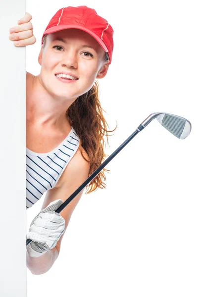 Golfista em um boné com um taco de golfe espreitando por trás de um poste — Fotografia de Stock