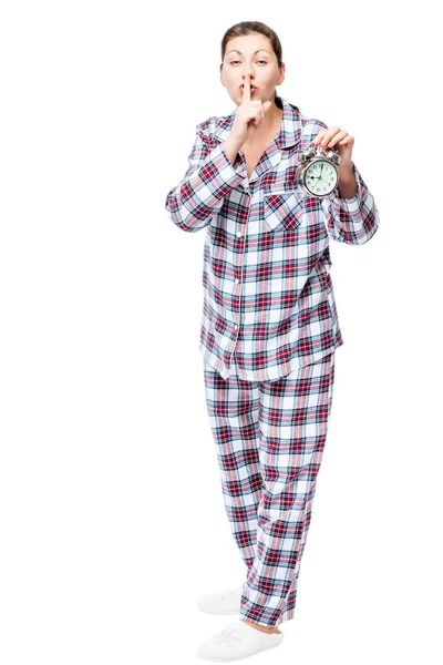 Девушка с будильником в клетчатой пижаме показывает жест — стоковое фото