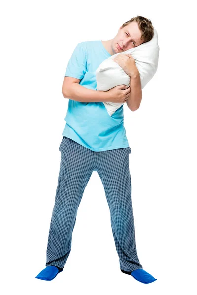 Joven hombre undersleeped en pijama con almohada sobre fondo blanco —  Fotos de Stock