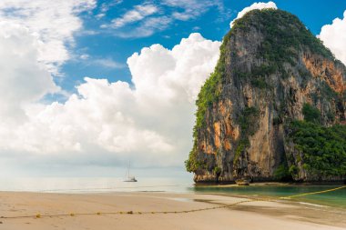 Güzel bulutlar, yüksek cliff ve deniz, Thail küçük bir yat