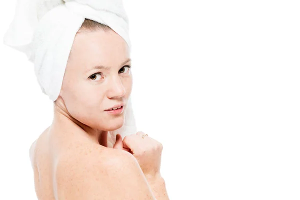 Femme avec des taches de rousseur sur sa peau dans une serviette regardant en arrière contre — Photo