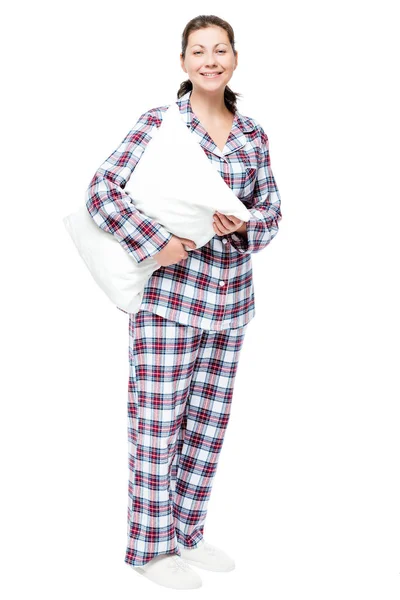 Улыбающаяся красивая девушка в пижаме и тапочках, обнимающая подушку — стоковое фото
