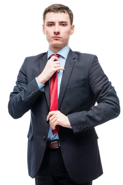 Hombre de traje corrige corbata roja, retrato sobre fondo blanco —  Fotos de Stock