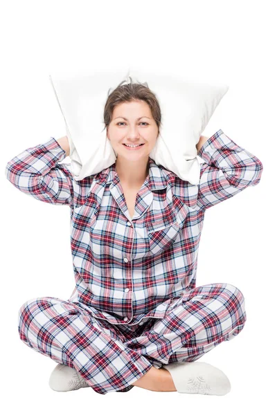 Woman in pajamas sitting on white background with pillow under h — Stock Photo, Image