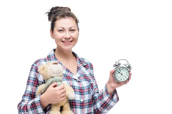 Hermosa mujer en pijama con oso de peluche y despertador en st — Foto de Stock