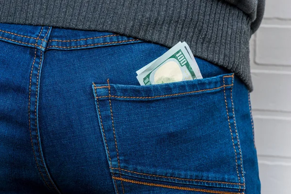 Доллары в заднем кармане мужских джинсов крупным планом — стоковое фото