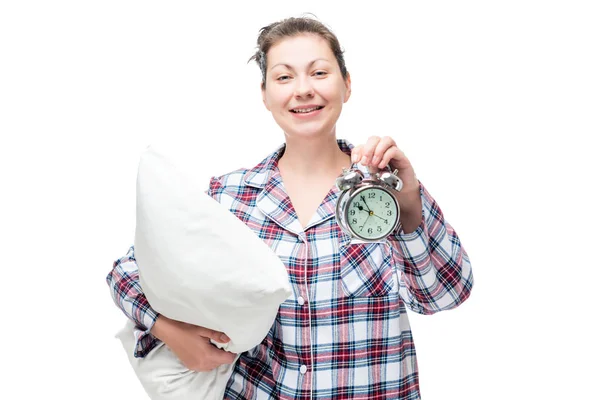 Счастливая женщина с подушкой в руке показывает позднее время на аль Стоковая Картинка