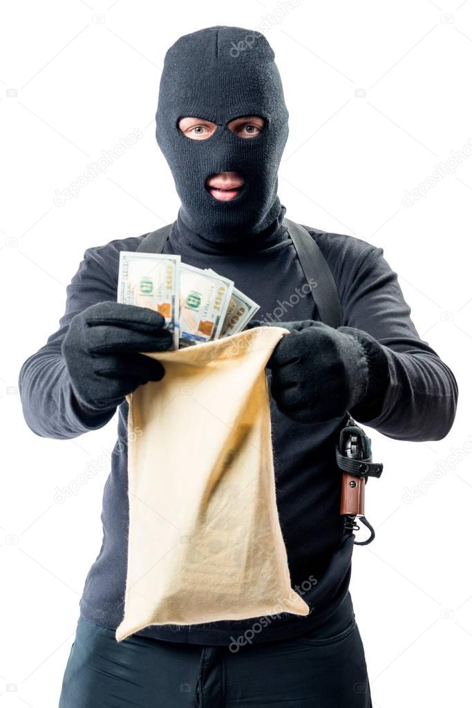 Male robber in full length is holding bag with money on white ba