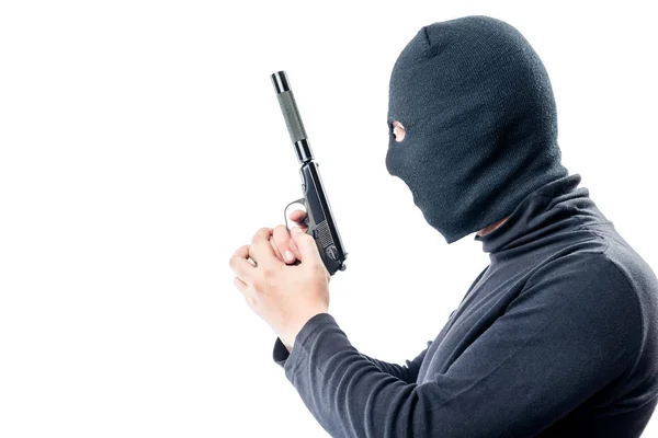 Assassino com uma arma em roupas pretas vista lateral em um backgrou branco — Fotografia de Stock