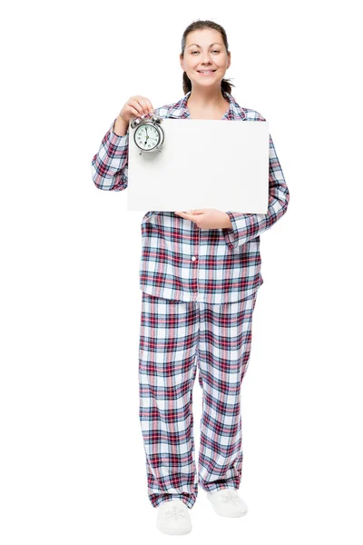 Hermosa mujer en pijama con un cartel y un reloj despertador befo —  Fotos de Stock
