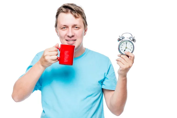 Hombre feliz con un despertador y café en la mañana temprano en — Foto de Stock