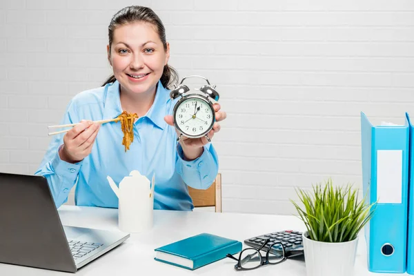 Menina contador no escritório com macarrão e um despertador em — Fotografia de Stock