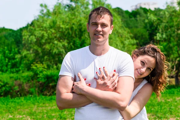 Verliebtes Paar umarmt sich auf Rasen im Park, Frau wartet auf Baby — Stockfoto