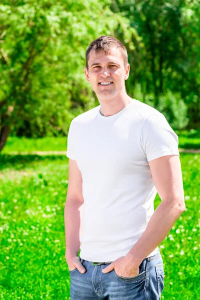 Vertical portrait of a sporty man in a summer park — Stock Photo, Image