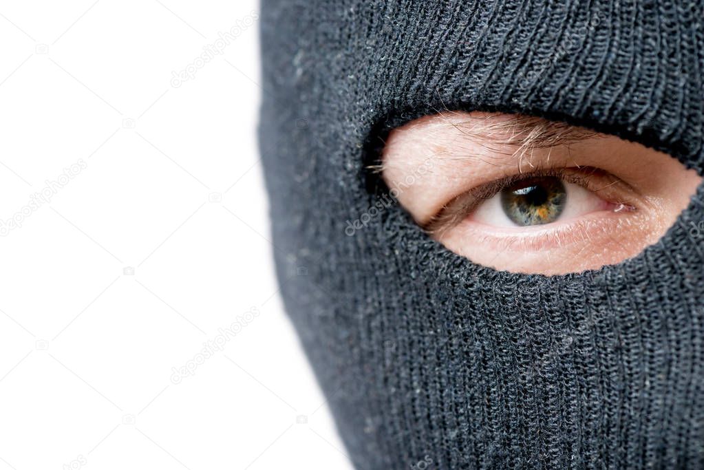 Close-up of the eyes of the criminal whose face is covered by a 