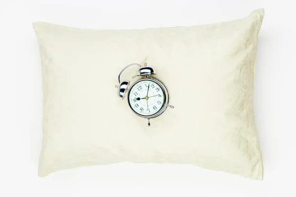 Retro alarm clock on the soft feather pillow close-up on a white — Stock Photo, Image