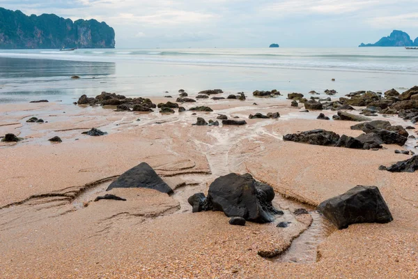 Nagy kövek, a homok, a tenger, rain a háttérben — Stock Fotó