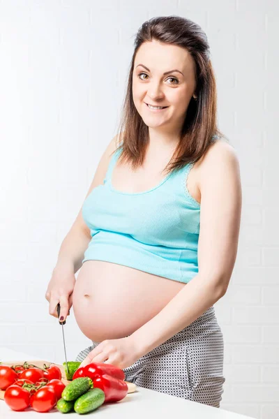 幸せな妊婦がランチに新鮮な野菜をカットします。 — ストック写真