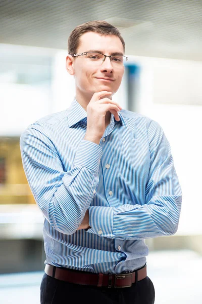 Portrait of smiling businessman in blue striped shirt in office