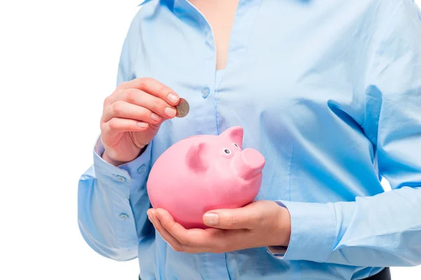 Manos femeninas primer plano de una moneda en una alcancía rosa — Foto de Stock