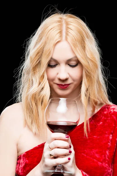 黒でワインのグラスと赤いドレスで美しいブロンド — ストック写真
