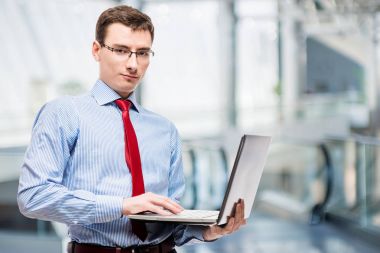 Yatay ofiste bir dizüstü bilgisayar ile bir işadamı portresi