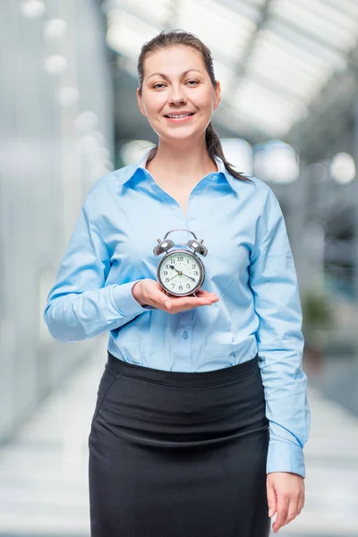 Empresária bem sucedida com um despertador nas mãos no escritório — Fotografia de Stock