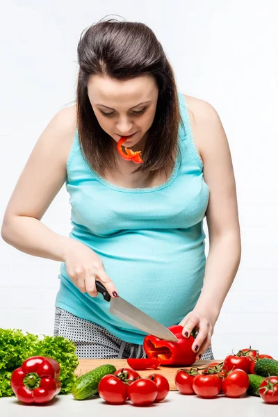 Schwangere bereitet Gemüsesalat in der Küche zu — Stockfoto