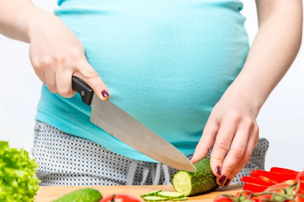 Junge schwangere Frau mit Messer in der Hand bereitet einen nützlichen Sal zu — Stockfoto