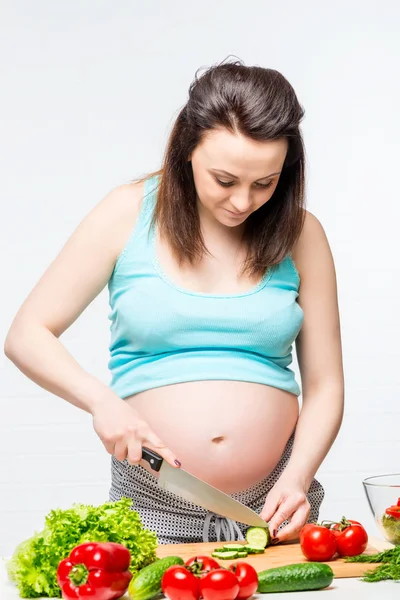 Junge schwangere Brünette bereitet gesunde Nahrung zu — Stockfoto