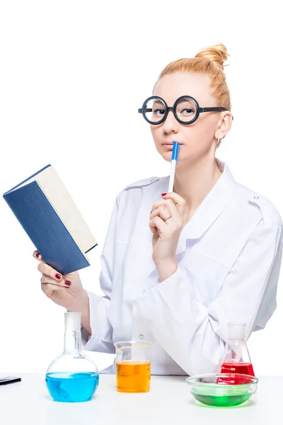 Estudiante de química divertida pensativa con un libro y tubos de ensayo en — Foto de Stock